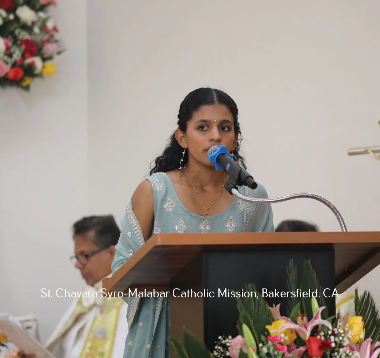 Young woman reading at the church lectern into a microphone during a service
