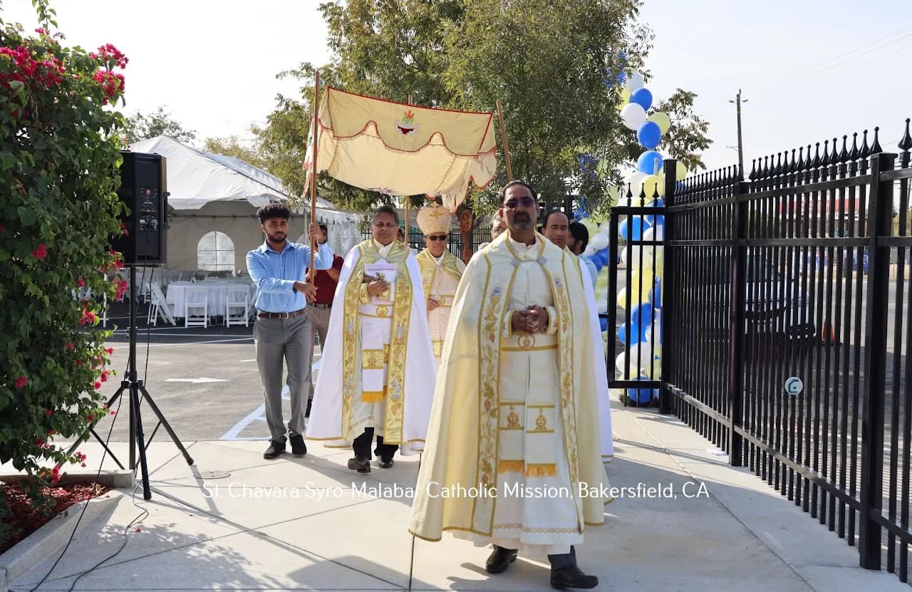 Priest leads a bishop under a ceremonial canopy in an outdoor parish procession