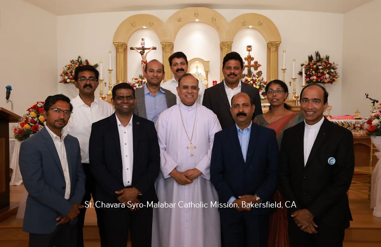 Bishop in white cassock posing with nine lay leaders and a priest in front of the altar
