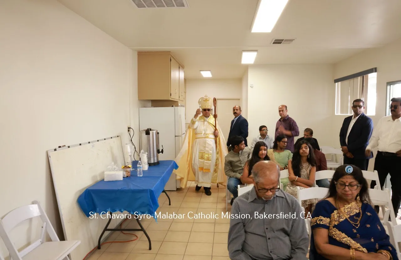 Bishop in mitre with crozier walking through a parish hall past seated parishioners