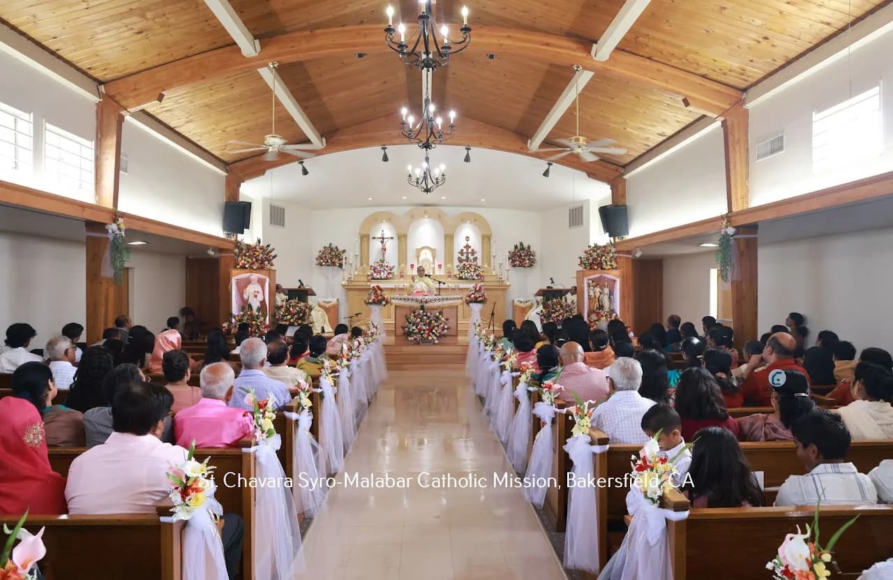 Packed church during a festal Mass, priest in gold vestments at a flower-banked altar, tulle bows on every pew
