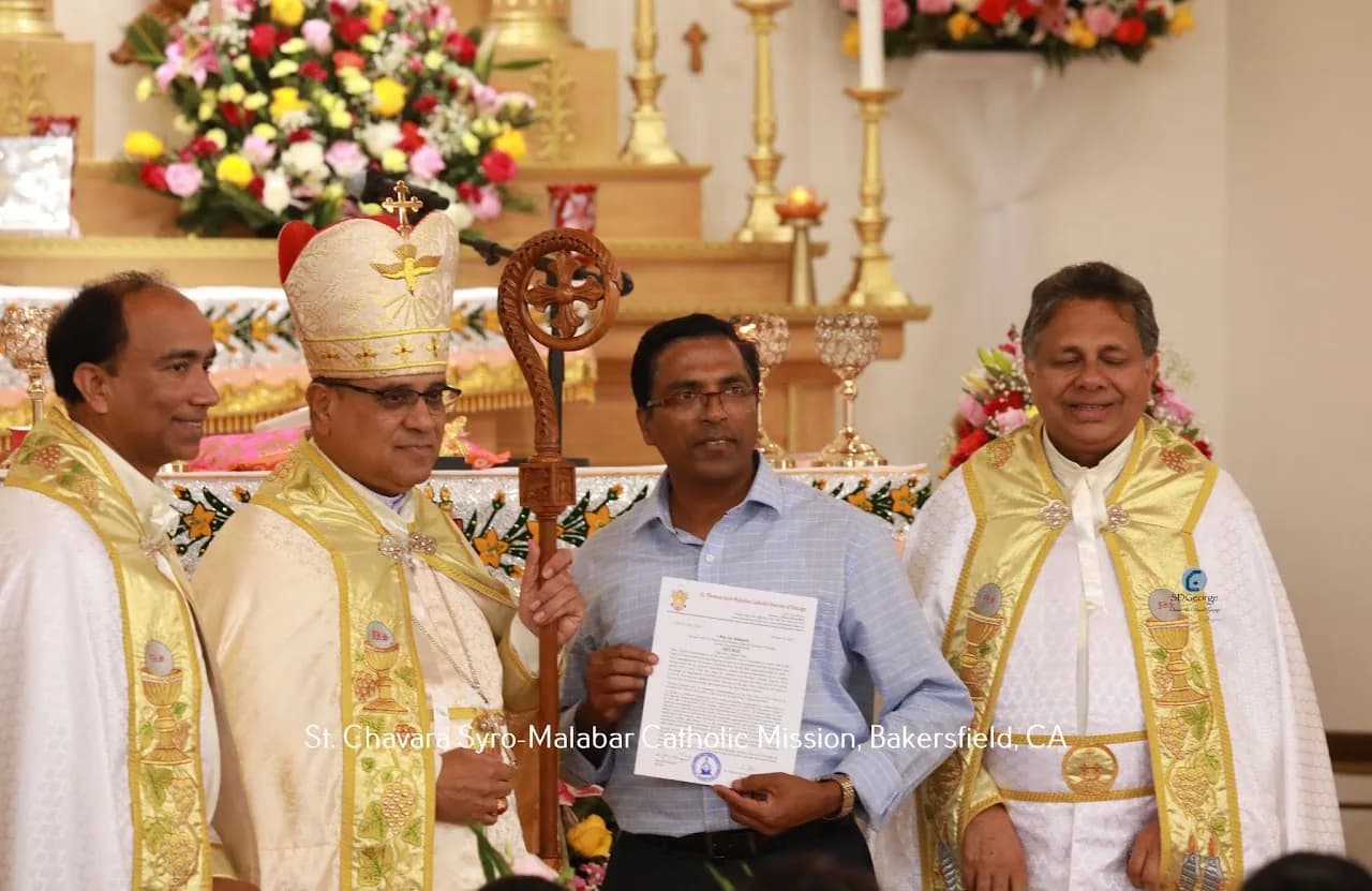 Bishop with crozier and two vested priests beside a layman holding a framed diocesan decree at the altar